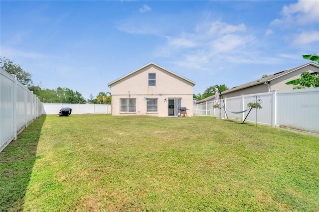 5118 Luna Negra Dr, Orlando, FL 32811 - rear view of house with a fenced backyard, a yard, and stucco siding