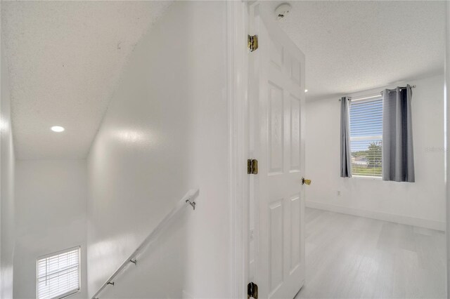5118 Luna Negra Dr, Orlando, FL 32811 - corridor with recessed lighting, an upstairs landing, baseboards, light wood-style flooring, and a textured ceiling