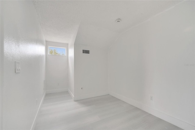 5118 Luna Negra Dr, Orlando, FL 32811 - empty room with baseboards, lofted ceiling, light wood-style floors, and visible vents