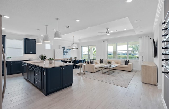 2725 Serenity Meadow Dr, Kissimmee, FL 34744 - kitchen featuring a center island, visible vents, a ceiling fan, light countertops, and a raised ceiling