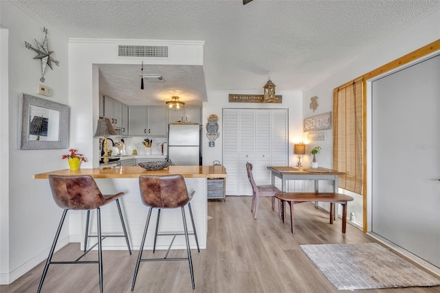 574 Orange Dr Unit 78, Altamonte Springs, FL 32701 - kitchen featuring light countertops, visible vents, freestanding refrigerator, a peninsula, and a textured ceiling