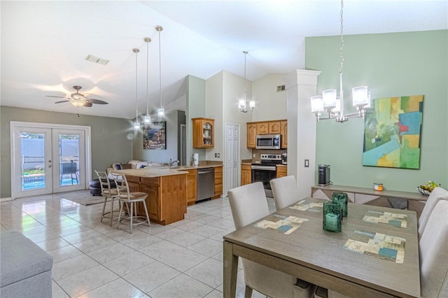 dining space featuring ceiling fan with notable chandelier, visible vents, high vaulted ceiling, and light tile patterned floors