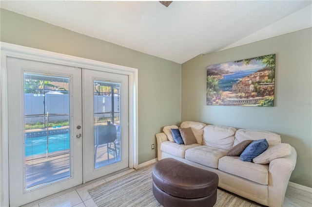 living room with light tile patterned floors, lofted ceiling, french doors, and baseboards