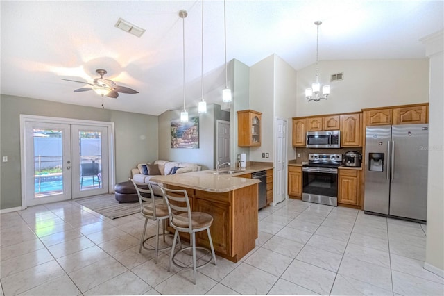 kitchen with a peninsula, stainless steel appliances, visible vents, and a sink