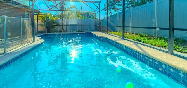 view of pool featuring a fenced backyard, glass enclosure, and a fenced in pool