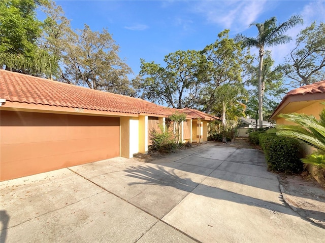 5037 Bermuda Cir Unit 10, Orlando, FL 32808 - view of front of property featuring a tile roof, driveway, and stucco siding