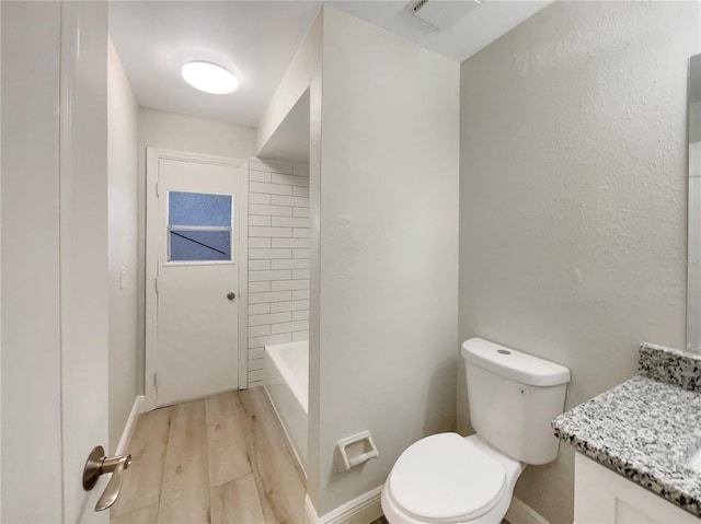 5037 Bermuda Cir Unit 10, Orlando, FL 32808 - bathroom featuring baseboards, wood finished floors, vanity, and toilet