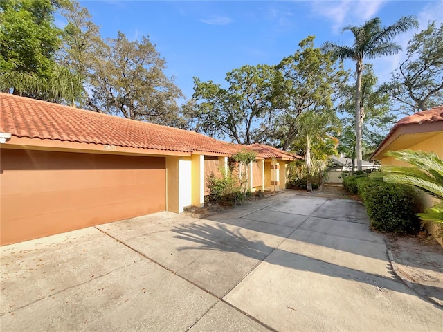 5037 Bermuda Cir Unit 10, Orlando, FL 32808 - view of front facade with stucco siding, driveway, and a tiled roof