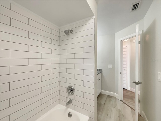 5037 Bermuda Cir Unit 10, Orlando, FL 32808 - bathroom featuring  shower combination, visible vents, baseboards, wood finished floors, and vanity