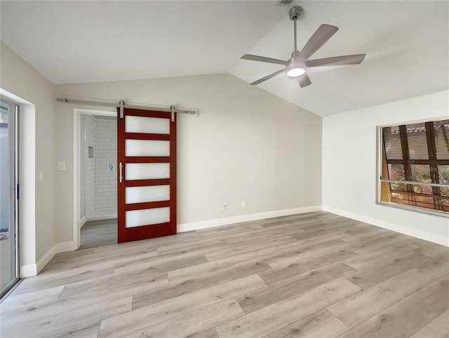 5037 Bermuda Cir Unit 10, Orlando, FL 32808 - unfurnished room with a barn door, vaulted ceiling, a ceiling fan, light wood finished floors, and baseboards
