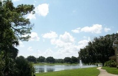 surrounding community with a lawn and a water view