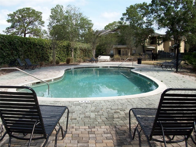 pool with fence and a patio area
