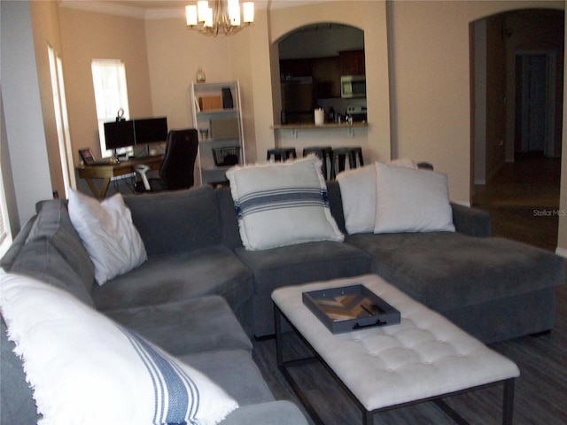 living room with a chandelier, arched walkways, and crown molding