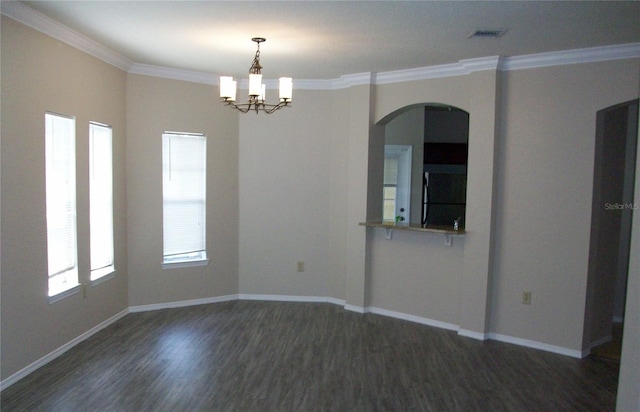 unfurnished room with crown molding, arched walkways, dark wood finished floors, baseboards, and a notable chandelier