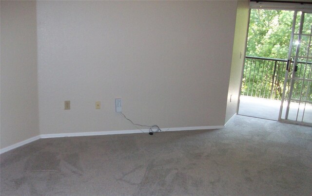carpeted empty room featuring baseboards