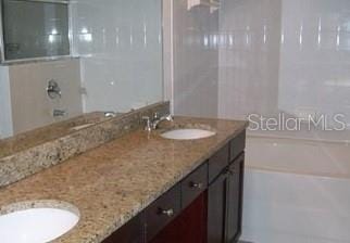 full bathroom featuring a sink and double vanity