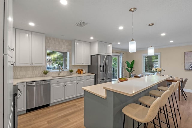 1105 Lake Nettie Dr, Eustis, FL 32726 - kitchen featuring stainless steel appliances, a kitchen bar, light wood-style flooring, tasteful backsplash, and a center island