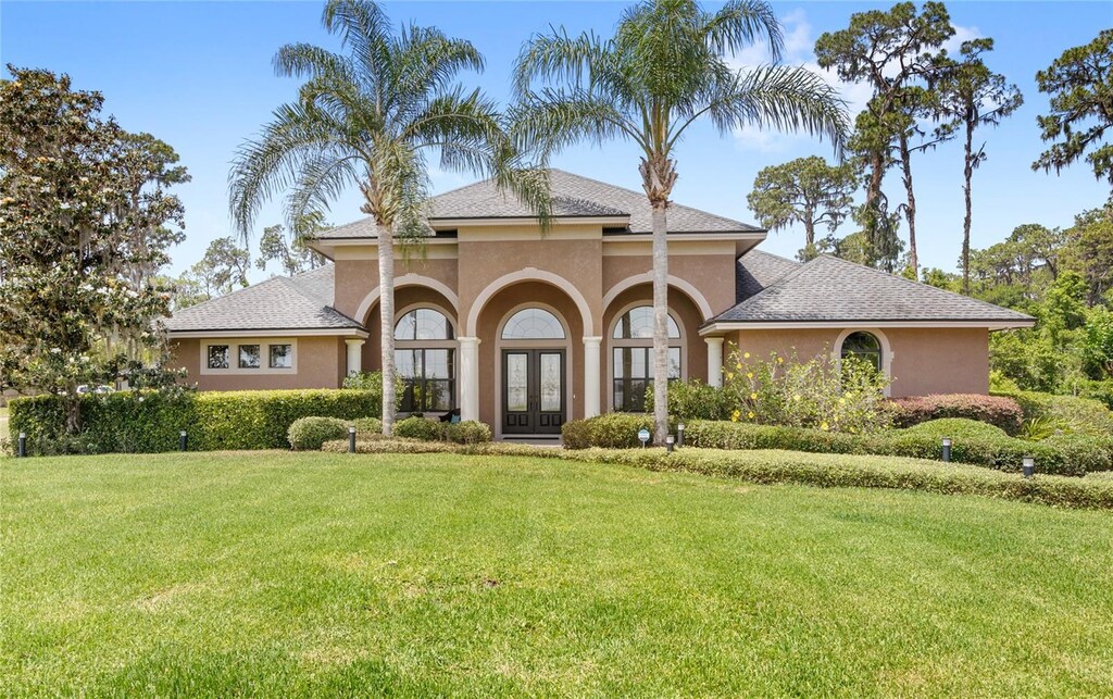 view of front of property with french doors, a front yard, and stucco siding