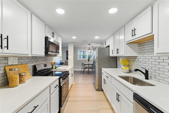 2716 Herrick Dr, Jacksonville, FL 32211 - kitchen with appliances with stainless steel finishes, a sink, white cabinetry, and light countertops