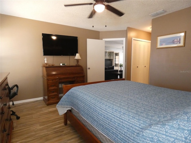 9313 Pavillion Dr, Orlando, FL 32825 - bedroom featuring wood finished floors, visible vents, a closet, baseboards, and a textured ceiling
