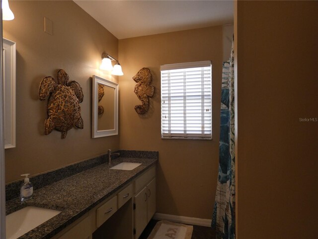 9313 Pavillion Dr, Orlando, FL 32825 - bathroom featuring double vanity, baseboards, and a sink