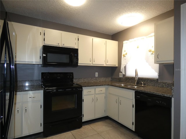 9313 Pavillion Dr, Orlando, FL 32825 - kitchen with a sink, a textured ceiling, black appliances, light tile patterned floors, and white cabinetry
