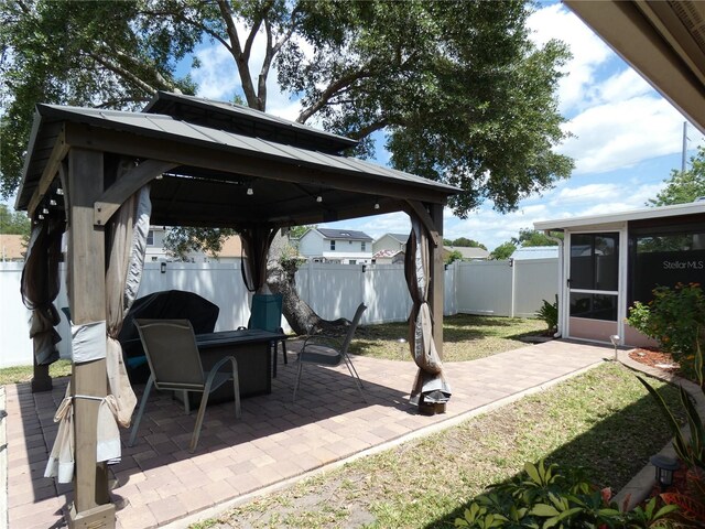 9313 Pavillion Dr, Orlando, FL 32825 - view of patio featuring a gazebo, a sunroom, a fenced backyard, and a fire pit