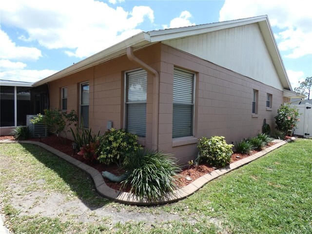 9313 Pavillion Dr, Orlando, FL 32825 - view of home's exterior featuring a lawn, a sunroom, and concrete block siding