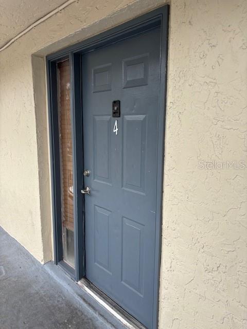 doorway to property featuring stucco siding