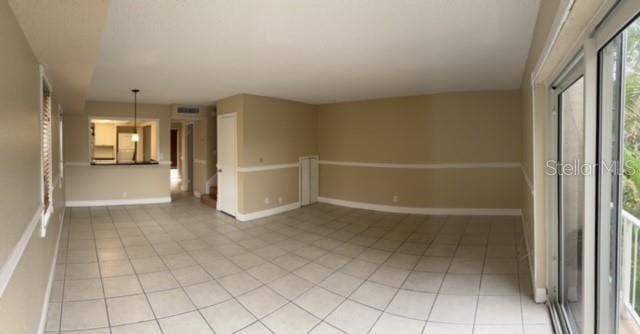 empty room with baseboards, visible vents, and light tile patterned floors