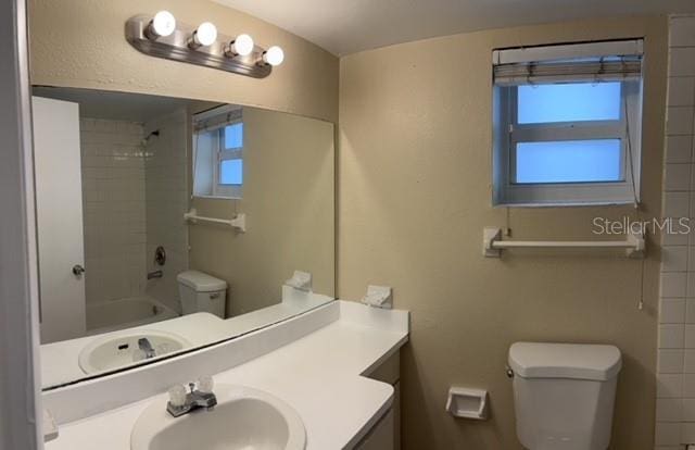 full bath featuring toilet, vanity, and shower / tub combination