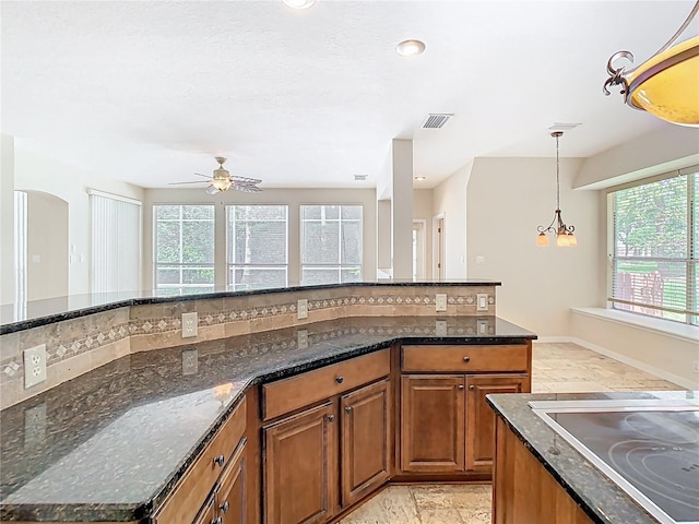 3020 Zaharias Dr, Orlando, FL 32837 - kitchen with a healthy amount of sunlight, brown cabinetry, and black electric cooktop