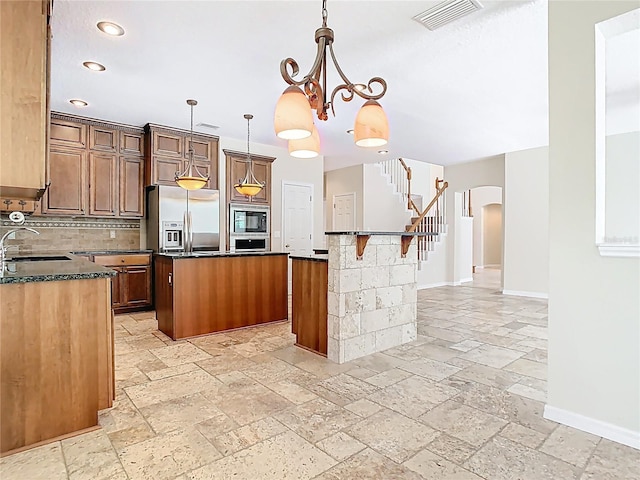 3020 Zaharias Dr, Orlando, FL 32837 - kitchen featuring a kitchen island, visible vents, built in microwave, stainless steel fridge, and stone tile floors