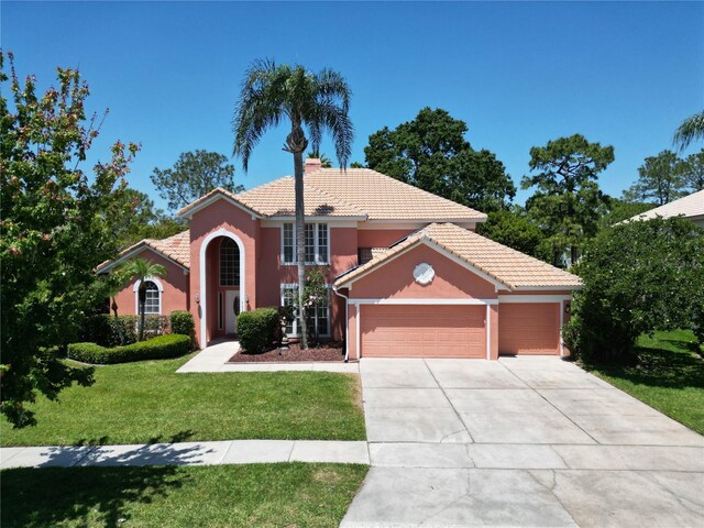 3020 Zaharias Dr, Orlando, FL 32837 - mediterranean / spanish-style home featuring a tiled roof, a garage, a front lawn, driveway, and stucco siding