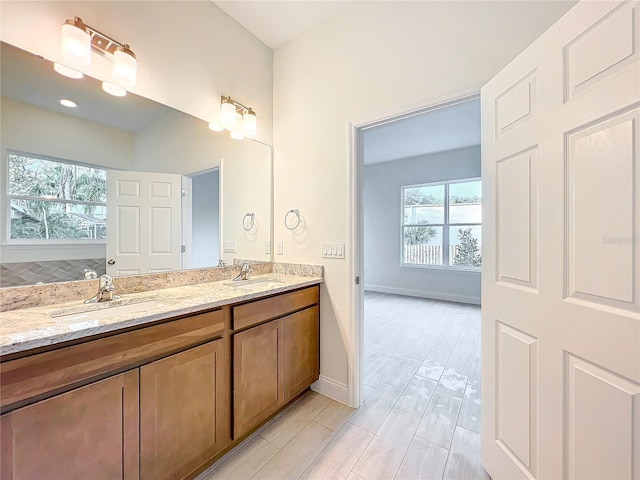 bathroom featuring plenty of natural light, a sink, and double vanity