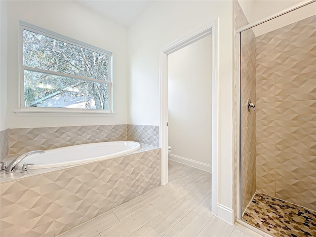 full bath with a bath, tile patterned floors, a shower stall, and toilet