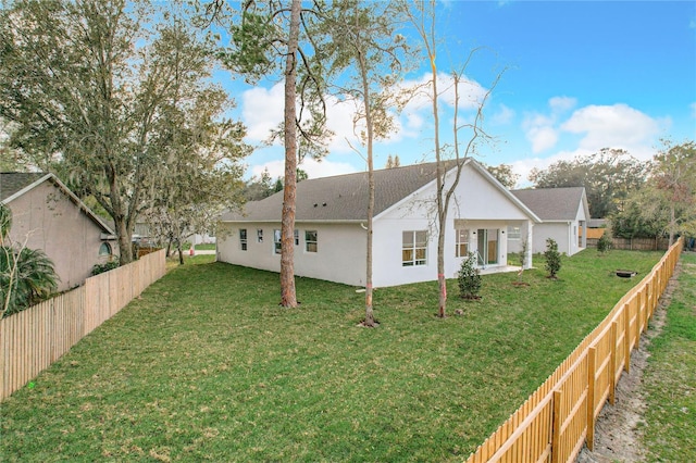 exterior space with a lawn, a fenced backyard, and stucco siding