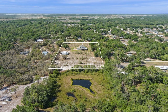 bird's eye view with a wooded view