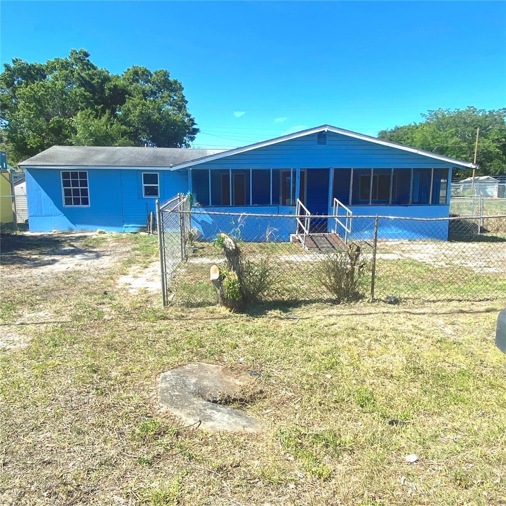 311 E Bridgers Ave, Auburndale, FL 33823 - view of front of home with a sunroom, a front lawn, and fence
