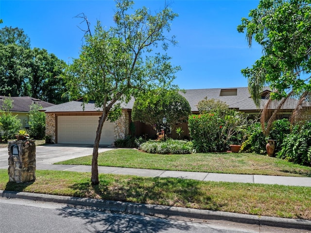 1139 Fairway Dr, Winter Park, FL 32792 - view of front of house with an attached garage, concrete driveway, a front lawn, a shingled roof, and stone siding