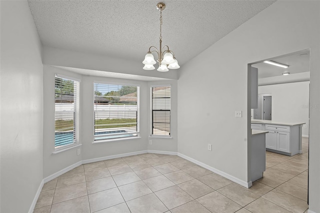 unfurnished dining area with baseboards, a textured ceiling, a notable chandelier, and light tile patterned floors