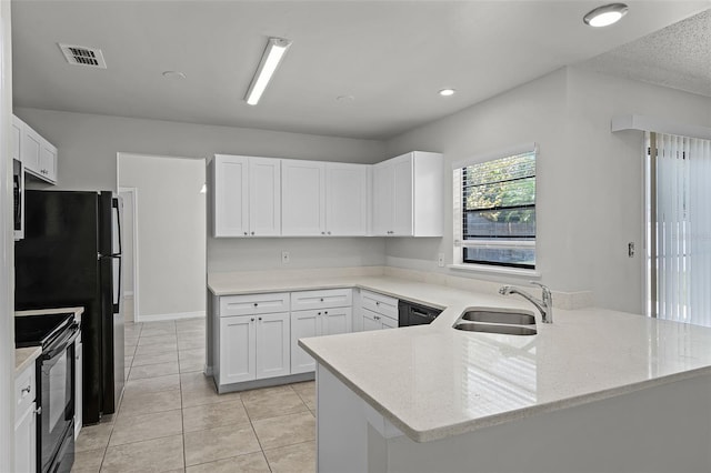 kitchen with visible vents, a sink, black appliances, a peninsula, and white cabinetry