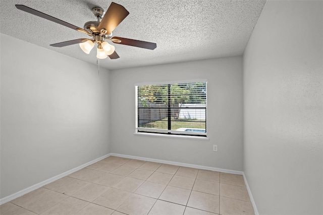 empty room featuring ceiling fan, baseboards, a textured ceiling, and light tile patterned floors