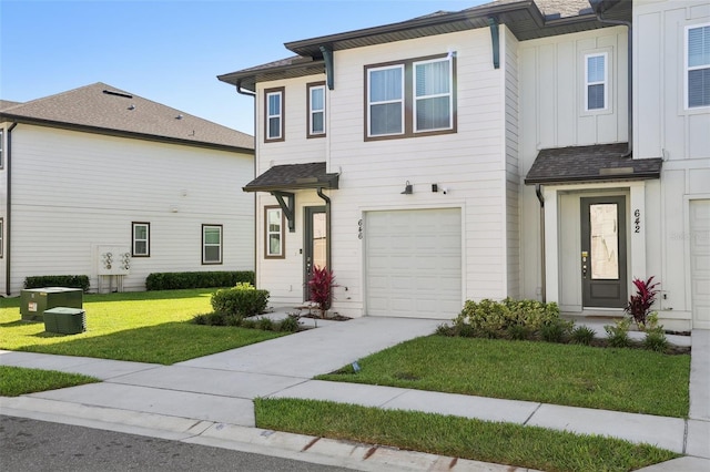 646 Longboat Dr, Davenport, FL 33896 - townhome / multi-family property featuring concrete driveway, a front lawn, board and batten siding, and a garage