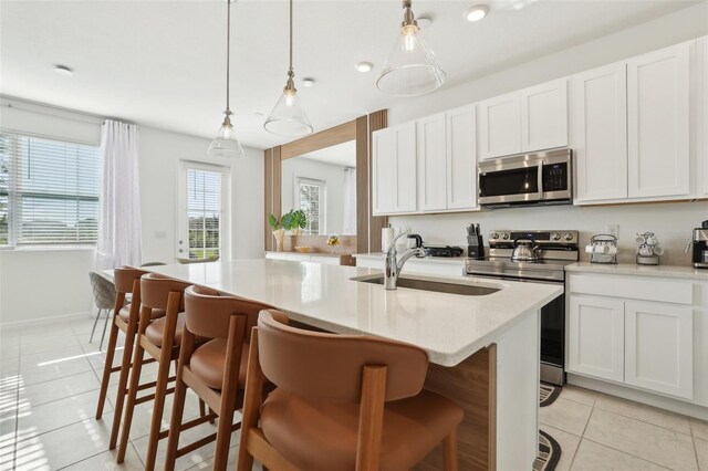 646 Longboat Dr, Davenport, FL 33896 - kitchen featuring a kitchen breakfast bar, an island with sink, stainless steel appliances, a sink, and light tile patterned flooring