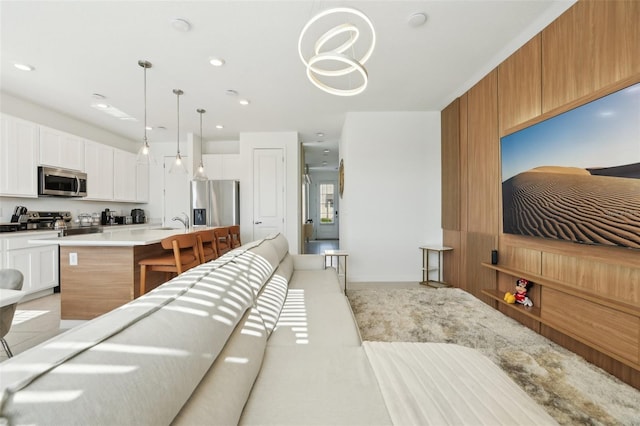 646 Longboat Dr, Davenport, FL 33896 - interior space with white cabinets, a kitchen breakfast bar, light countertops, hanging light fixtures, and appliances with stainless steel finishes