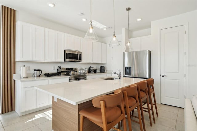 646 Longboat Dr, Davenport, FL 33896 - kitchen featuring light tile patterned floors, a sink, appliances with stainless steel finishes, a breakfast bar area, and white cabinetry