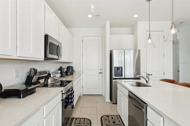 646 Longboat Dr, Davenport, FL 33896 - kitchen featuring white cabinets, a sink, light tile patterned flooring, appliances with stainless steel finishes, and hanging light fixtures