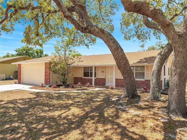 ranch-style house with a shingled roof, stucco siding, concrete driveway, brick siding, and a garage