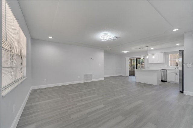 unfurnished living room with light wood finished floors, baseboards, visible vents, and recessed lighting